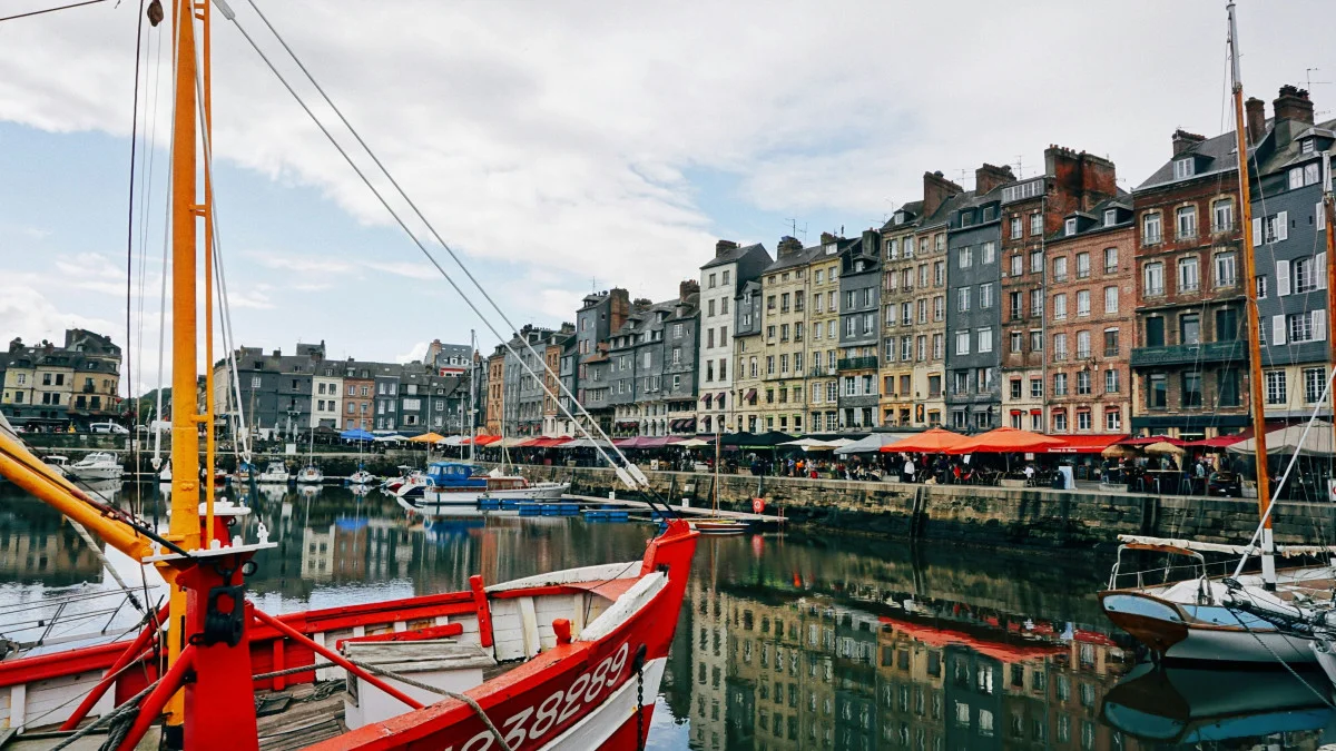 Vieux bassin du port de Honfleur avec ses hautes maisons étroites et des bateaux amarrés